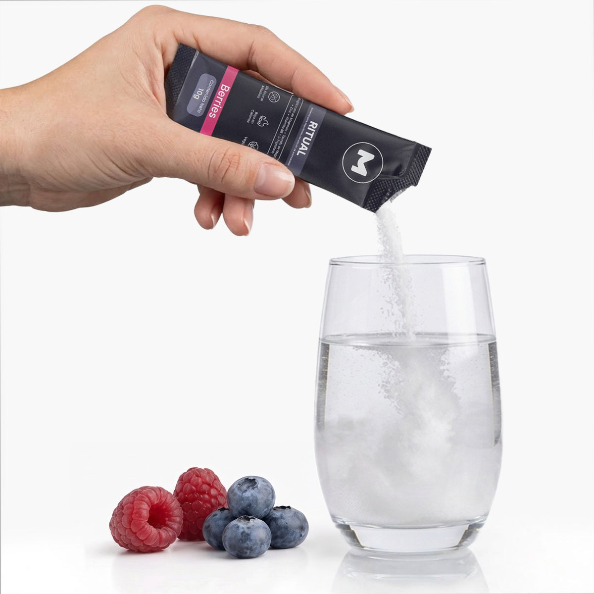 RITUAL: vertiendo el sachet de polvo sabor berries en un vaso de agua, con arándanos y frambuesas